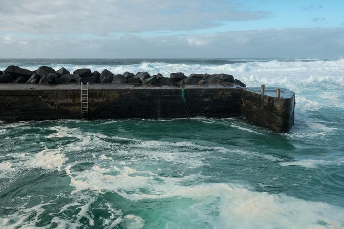 Sea waving near stone pier