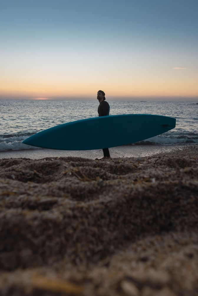 Man practicing paddle surfing with neoprene in a sunrise
