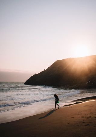 Silhouette of person on seashore during golden hours