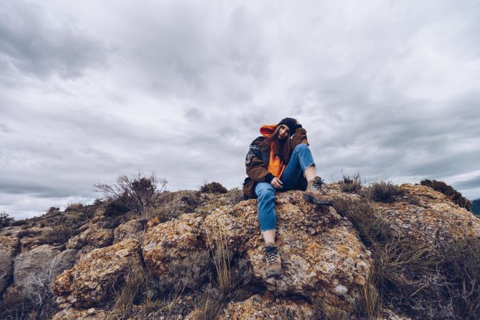 Cheerful woman resting on mountain top
