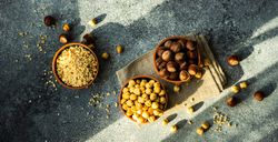 Top view of whole, shelled & chopped hazelnuts in bowls