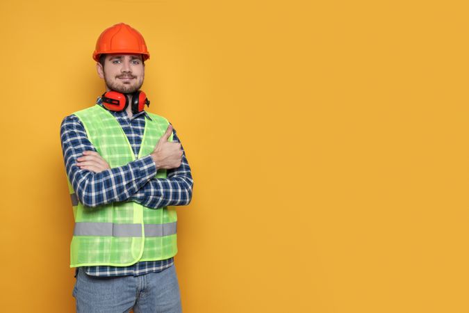 Engineer in helmet on yellow background, space for text