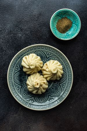 Top view of patterned plate with three Georgian khinkali dumplings