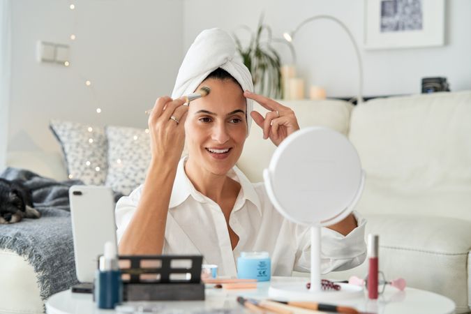 Content woman recording beauty tutorial on smartphone