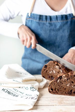 Hands of woman cutting rye bread