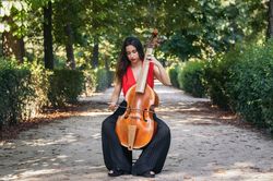 Woman playing the cello in a park.