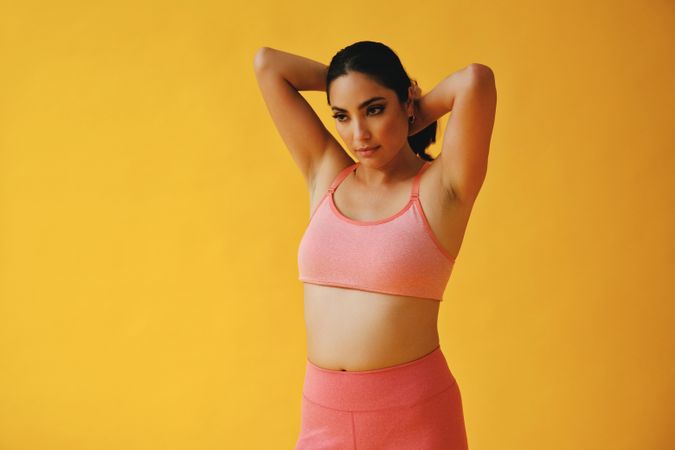 Hispanic woman in yoga clothes fixing her hair, copy space