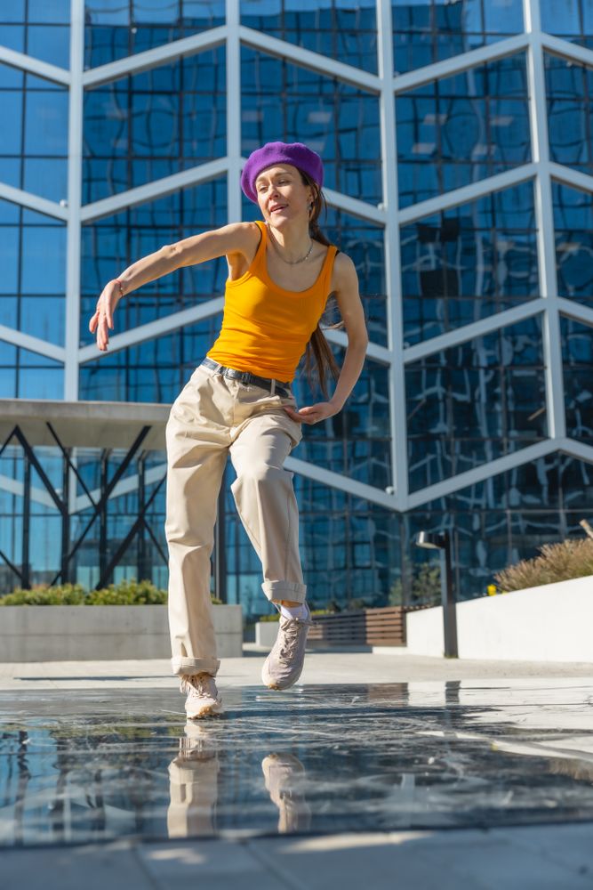Vertical Screen: Young And Stylish Female Hip Hop Dancer Freestyling On City Street. Professional Street Performer Doing Improvisation In Urban Environment.