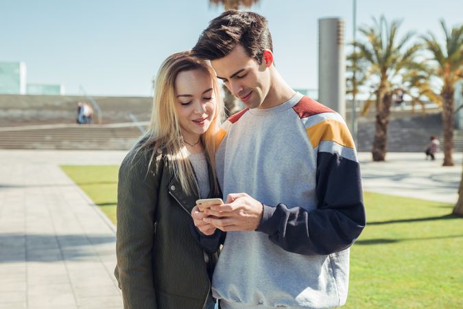 Couple using phone outdoors