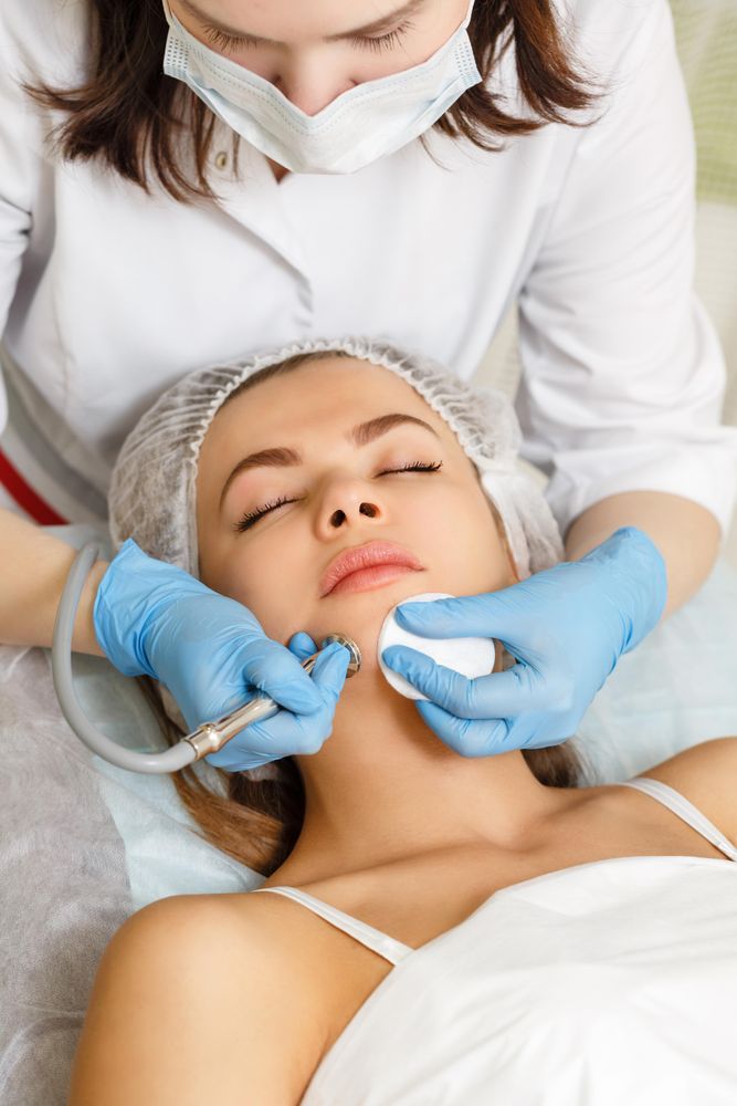 Woman having facial beauty treatment with instrument on her chin