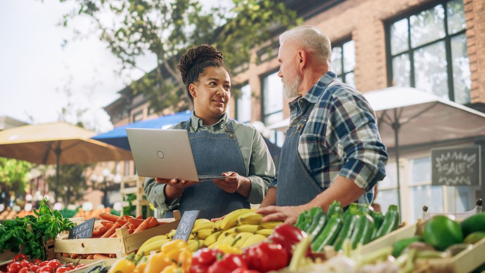 Female and Male Business Partners Managing a Successful Organic Farmers Market Marketplace.