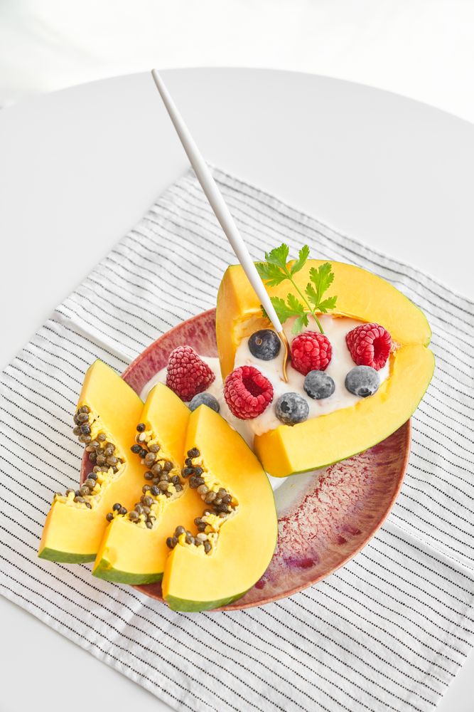 Delicious papaya dessert with berries on table