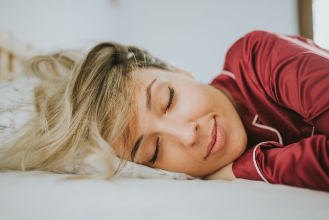 Woman sleeping and smiling in bed