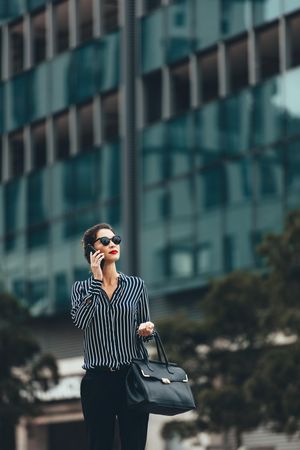 Female business professional walking outside with an office building in background