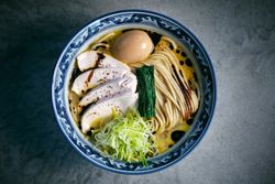 Tasty ramen with cooked noodles and fresh vegetables in bowl