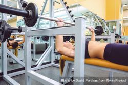 Woman doing bench press in gym 41QmO4