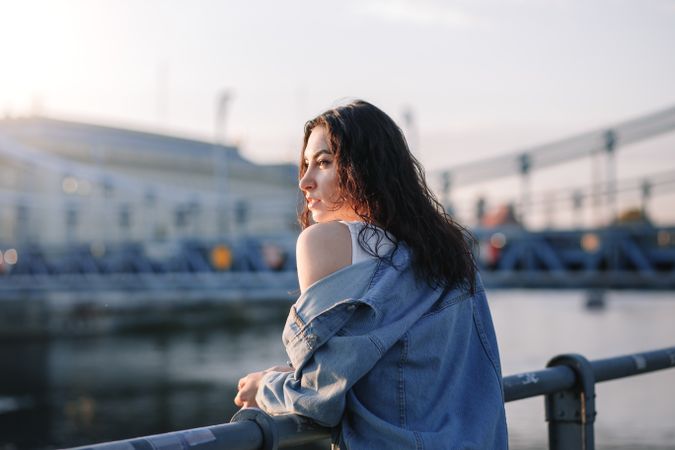 Woman leaning on railing along the waterfront