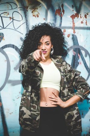 Trendy sportive woman pointing at camera confidently