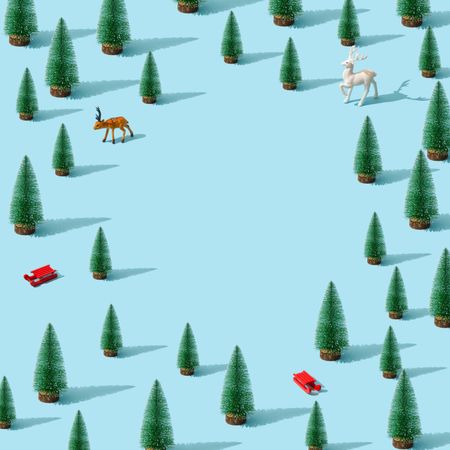 Minimal winter landscape scene with pine trees and reindeers