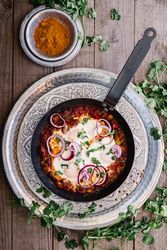 Fragrant shakshuka with onion rings in pan
