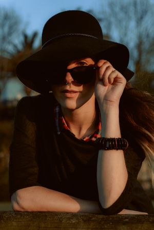 Dreaming stylish woman in sunglasses and hat