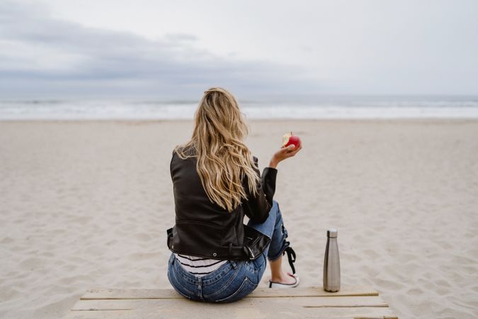 Woman with apple on beach