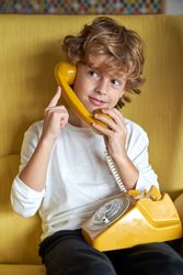 Content child having conversation on retro phone