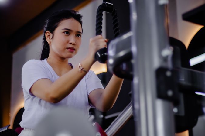 Focused determined woman trains triceps at fitness center