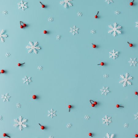 Christmas pattern made of snowflakes and red berries on blue background