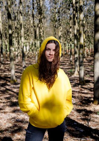 Sporty girl standing in forest in yellow
