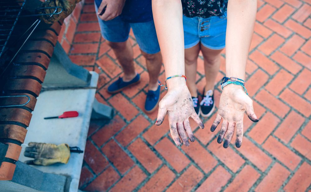 Woman showing her hands dirty of coal