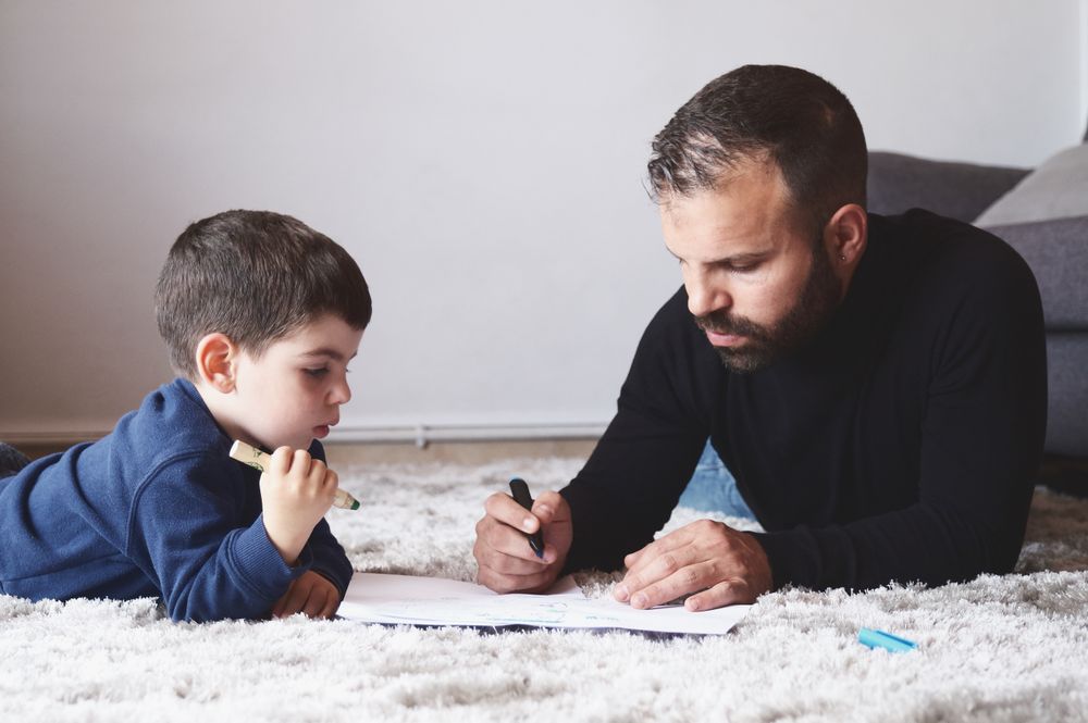 Father and son drawing on floor