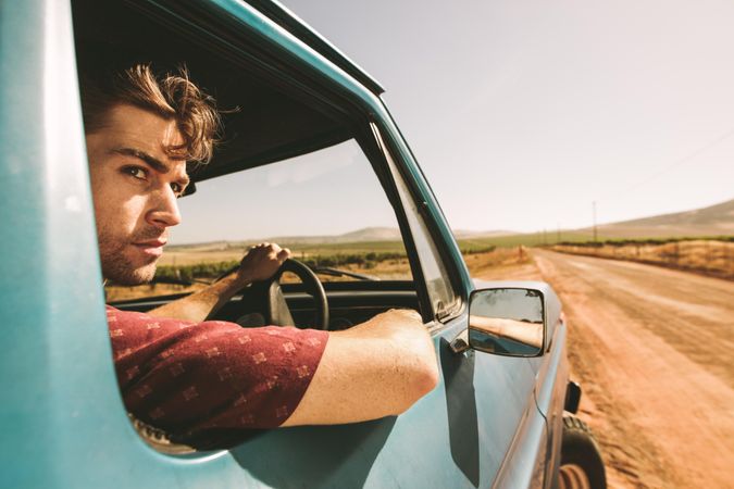 Close up of man looking out of the window while driving classic truck