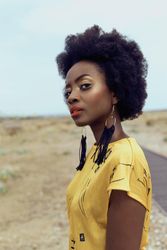 Side view of woman in yellow dress standing in desert