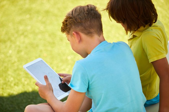 Boys using tablet in garden