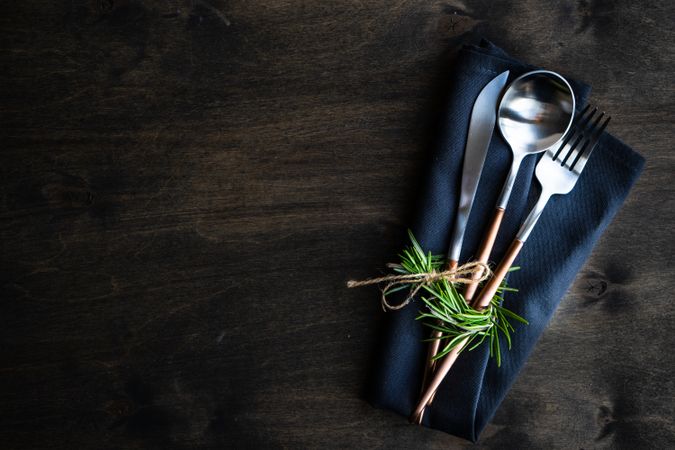 Cutlery set on rustic background with rosemary garnish