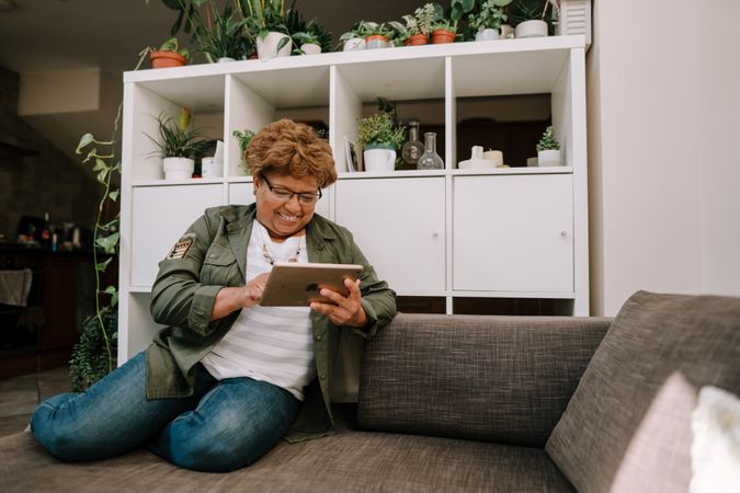 Older Black woman on sofa using tablet