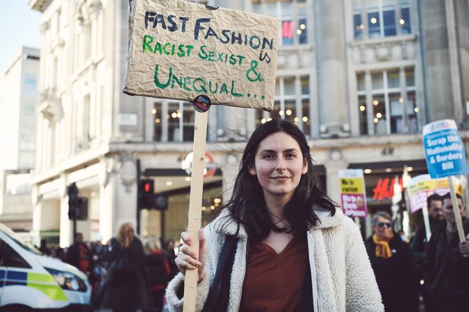 London, England, United Kingdom - March 19 2022: Woman with “Fast Fashion” sign at anti-racism march