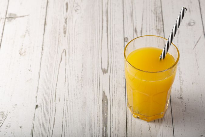 Glass with orange juice on the table.