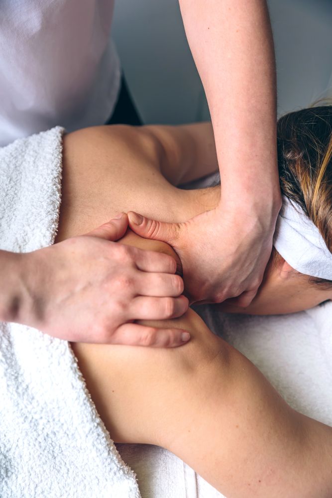 Close up of massage therapists giving massage to client's shoulders