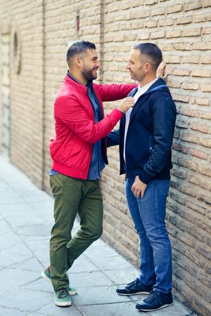 Side view of male couple in a romantic moment on the street, vertical