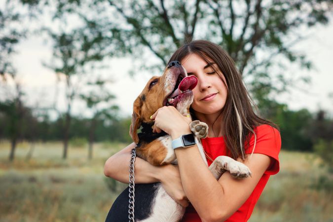 Young woman Embracing beagle