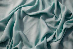 Nude green fabric wavy crumpled background texture with copy space.
