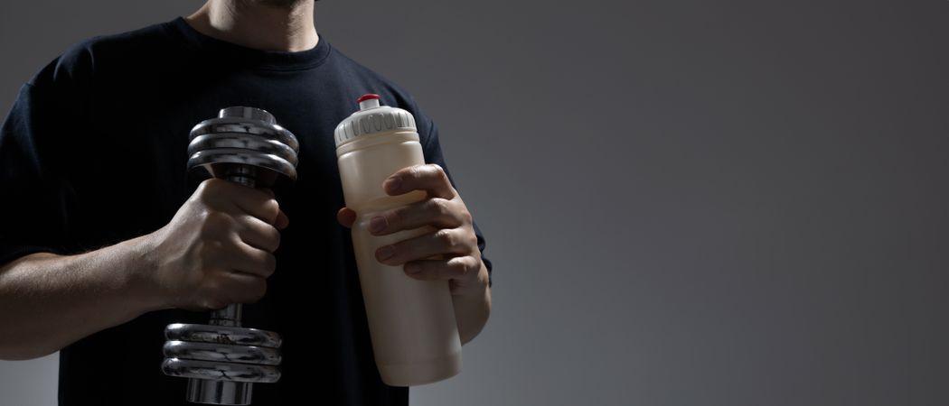 Man holding dumbbell and water bottle