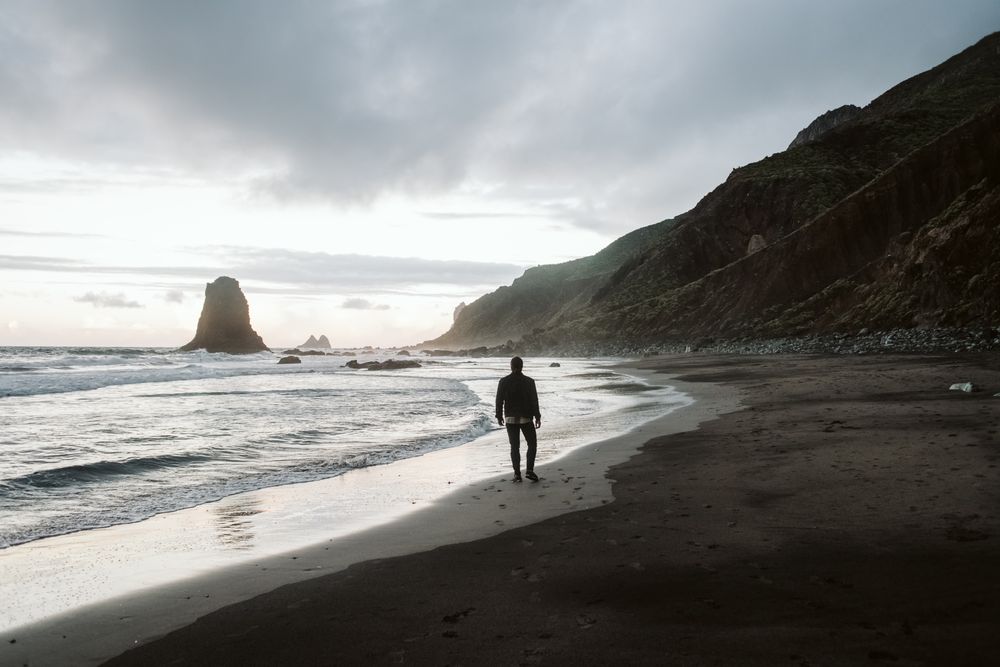 Anonymous man standing near sea