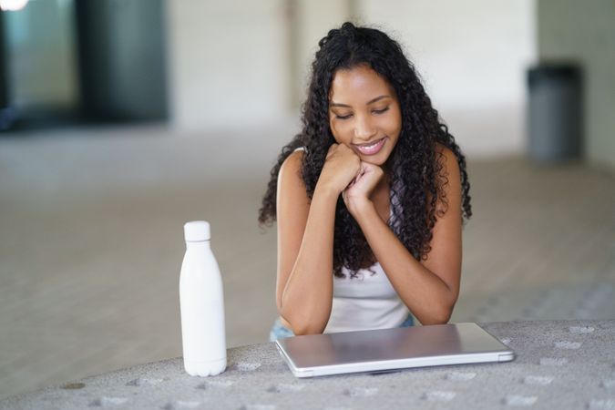 A Young Woman Engaged Deeply with Her Laptop While Seated Comfortably in a Casual Setting