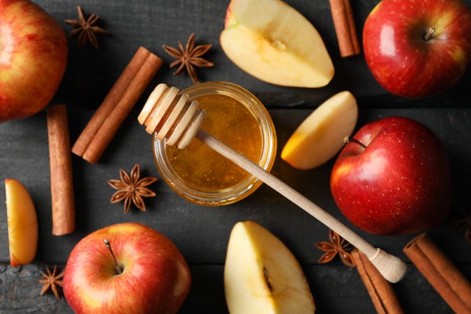 Autumnal apples and cinnamon sticks on dark wooden table