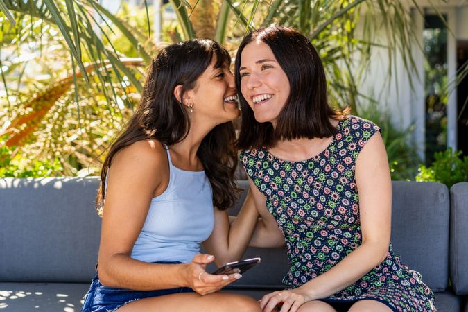 woman whispering a secret to her best friend