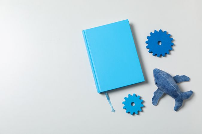 Blue children's book, with toys, on a plain background.