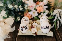 Easter eggs in container between decorative plants